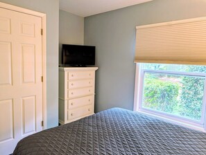 A bedroom with a bed, a dresser, a television, and a window with blinds. - Sea Colony 3BR Condo w/ Blue Screened Porch & Resort Amenities (Bethany Beach)