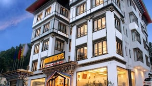 Un hotel de varios pisos con estilo arquitectónico tradicional, que cuenta con una entrada destacada y un letrero.