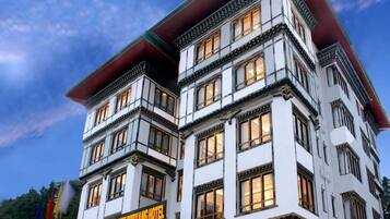 Un hotel de varios pisos con estilo arquitectónico tradicional, que cuenta con una entrada destacada y un letrero.
