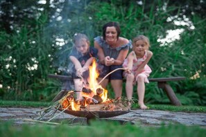 A campfire with people sitting around it. - Stein - Apartment Spreewald (Byhleguhre)