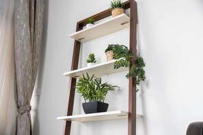A wooden ladder shelf with potted plants against a white wall. - StayShort - Stylish 2-Bedroom Escape in Dubai Marina for 4 guests! (Dubai Marina)