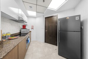 A modern kitchen with a built-in oven, a refrigerator, and a microwave. - StayShort - Stylish 2-Bedroom Escape in Dubai Marina for 4 guests! (Dubai Marina)