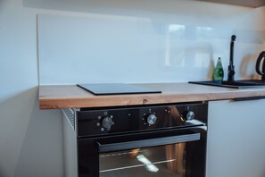 Una cocina con horno empotrado y encimera de madera.