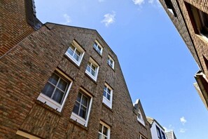 A multi-story brick building with several windows and a clear sky. - "Ferryman" in the cottage on the Rhine (Rees)