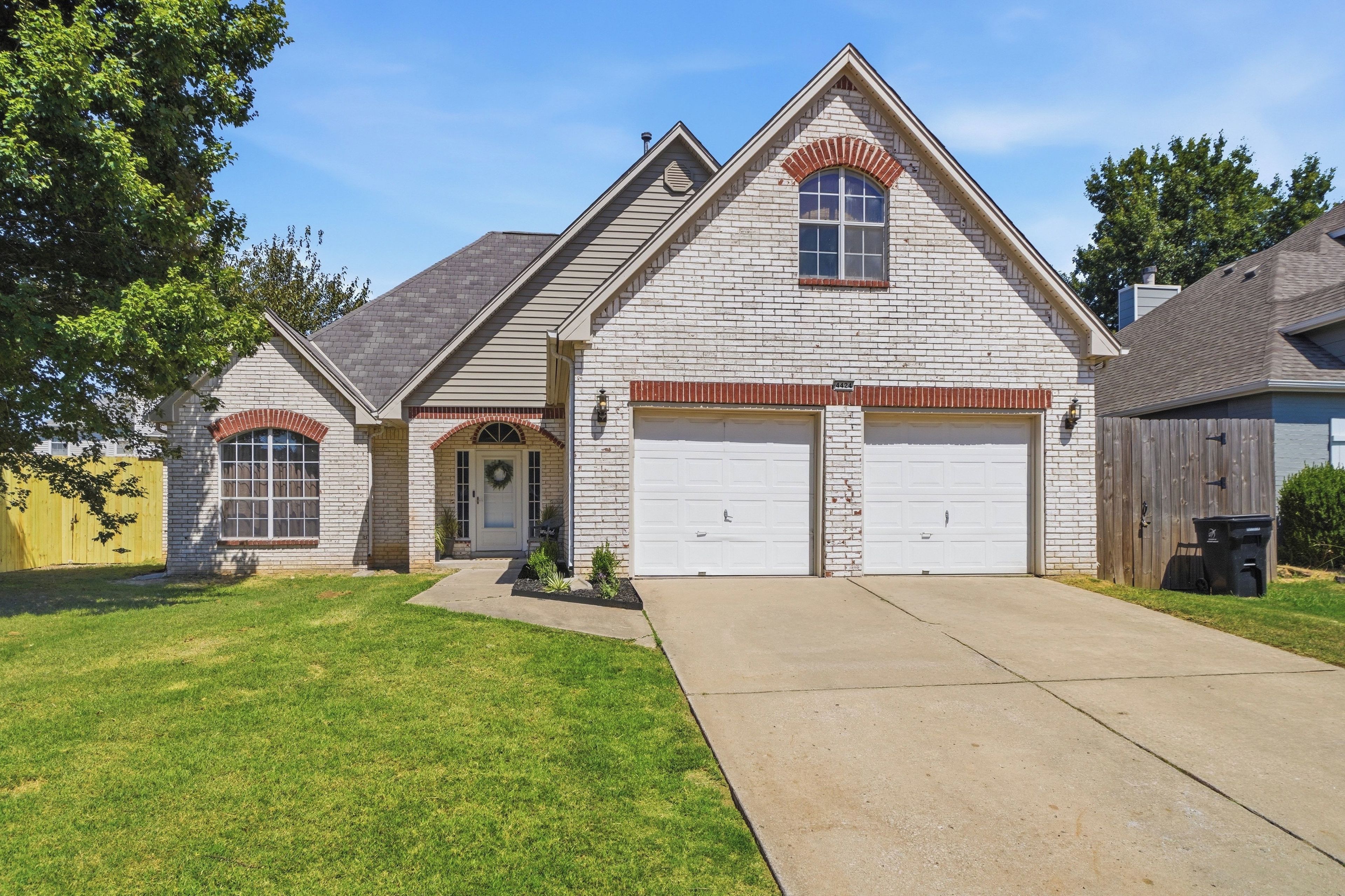 A two-story house with a brick facade, a front porch, and a garage.