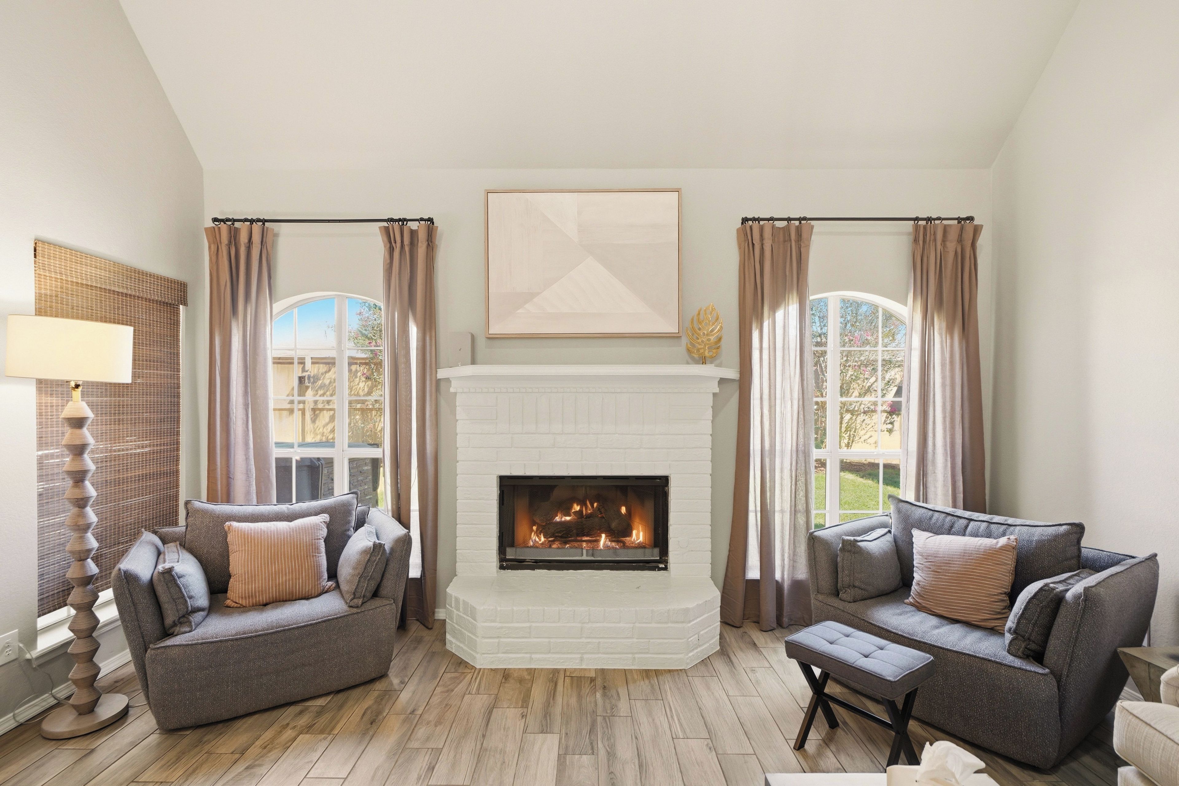 A living room with a fireplace, two sofas, a coffee table, and a lamp.