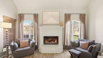 A living room with a fireplace, two sofas, a coffee table, and a lamp.