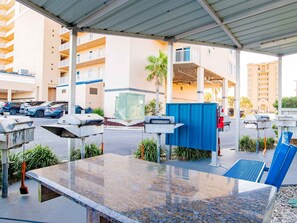 Un espace extérieur abrité comprenant une table de billard, des sièges et un parking.