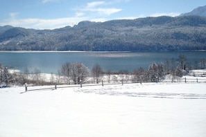 A snow-covered landscape with a lake, trees, and a wooden fence. - 4 - at the Füssen equestrian center (Weißensee-Füssen)