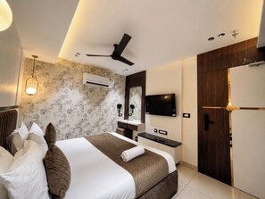 Habitación de hotel moderna con cama, escritorio, televisor y armario.