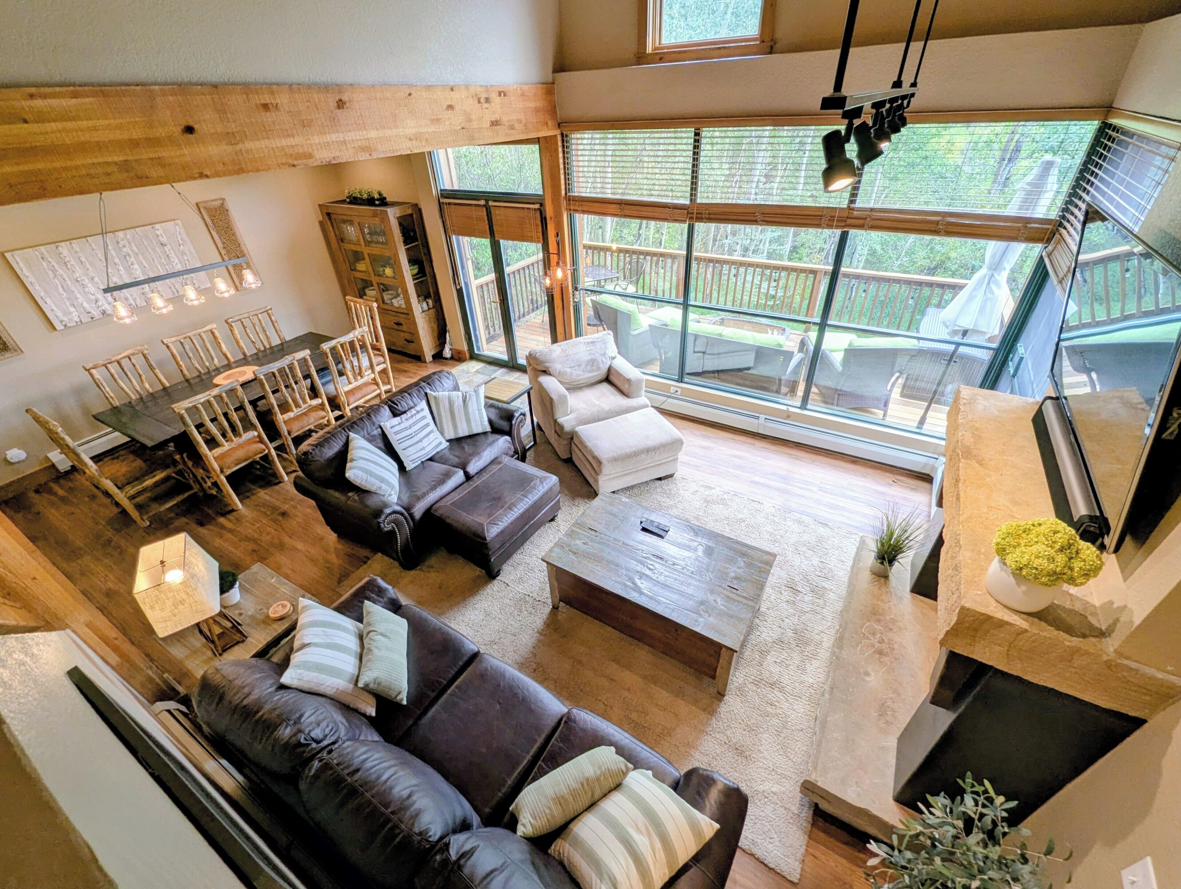 A spacious living area with a large window, a fireplace, and a dining set.
