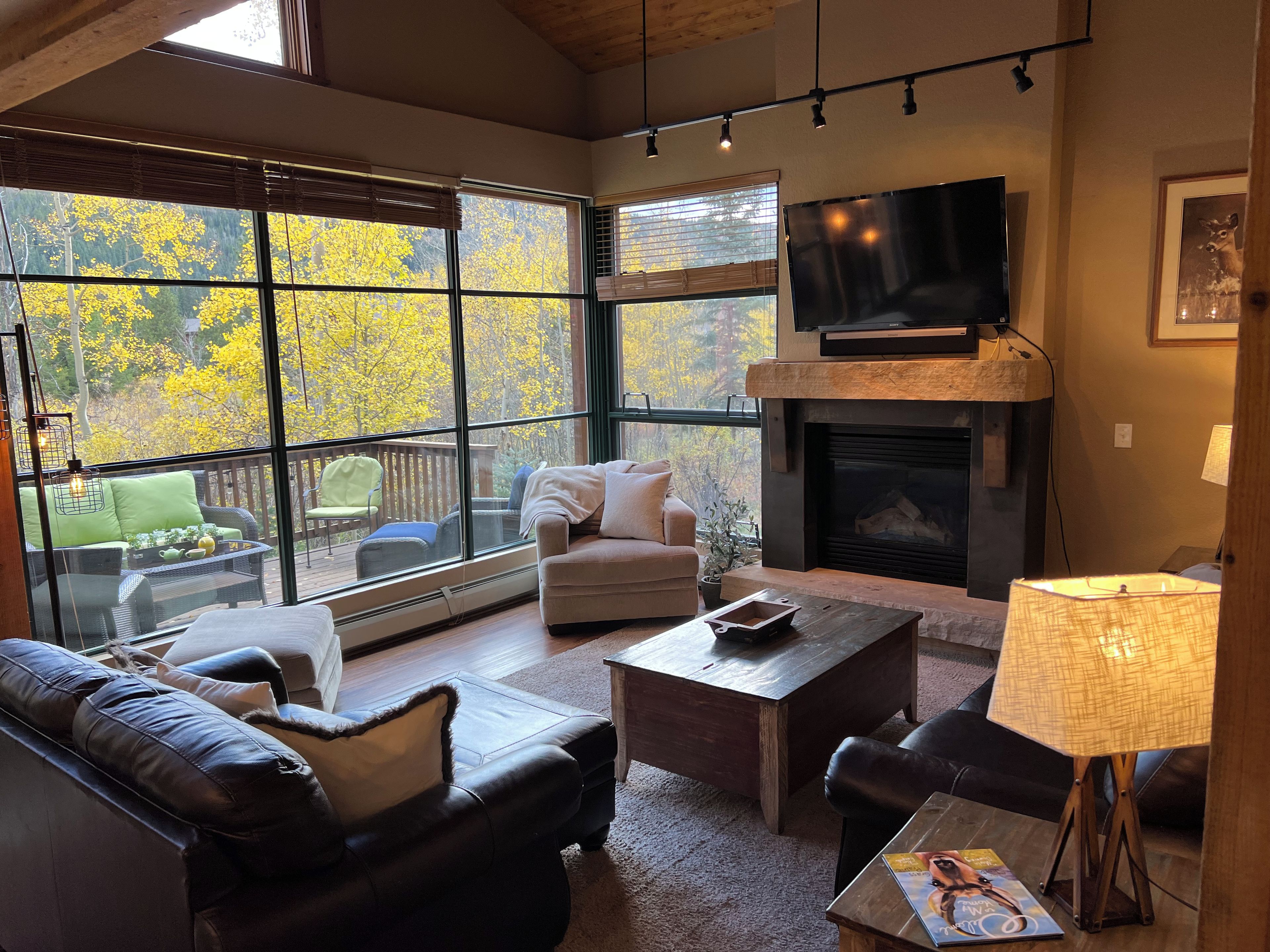 A spacious living room with a fireplace, large windows, and comfortable seating.