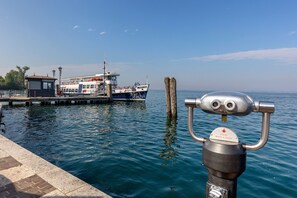 Eine Anlegestelle mit einem Boot, einer Metallkonstruktion und einem Hinweisschild, das über ruhiges Wasser blickt.