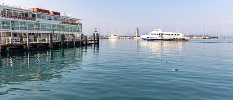 A waterfront hotel with a dock, a large white boat, and a clear sky.