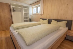 A bedroom with a bed, a wardrobe, and a window. - Holiday apartment with 2 bedrooms (Au im Bregenzerwald)