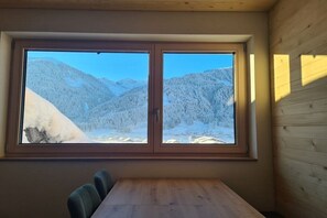 A room with a large window overlooking a snowy mountain landscape. - Holiday apartment with 2 bedrooms (Au im Bregenzerwald)