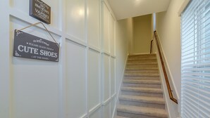 A staircase with a sign that says 'Welcome Please Leave Your CUTE SHOES (At the Door)'.