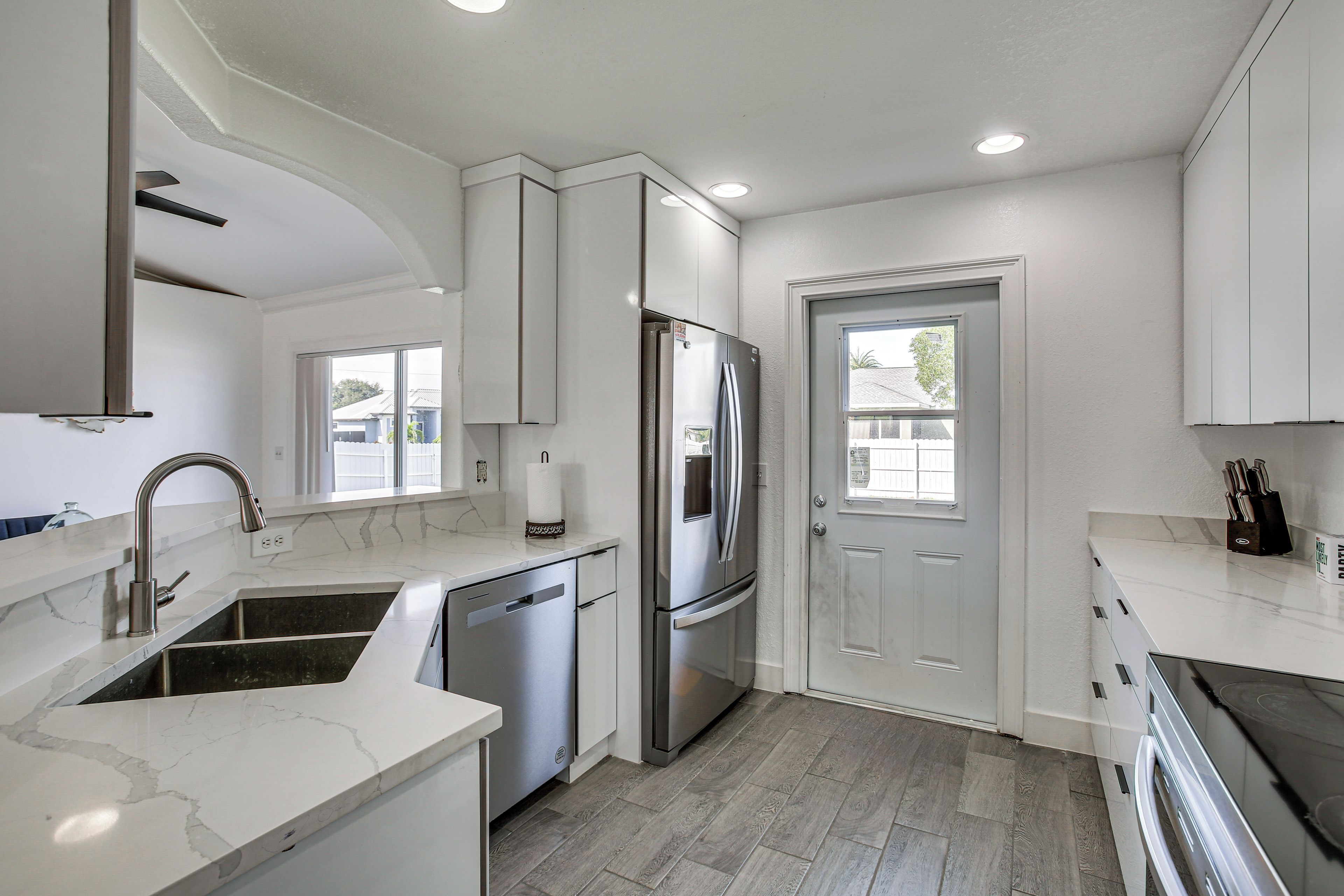 A modern kitchen with a stainless steel refrigerator, a dishwasher, and a sink with a faucet.