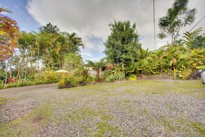 A garden with a gravel path, various tropical plants, and a white umbrella. - Ocean-view Group Retreat! 8 Mi to Magic Sands (Holualoa)