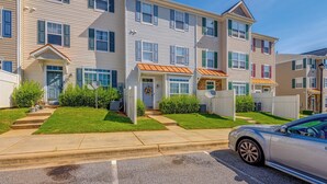 A row of townhouses with front porches, satellite dishes, and a car parked on the street. - Home Gym & Pool Access! North Raleigh Retreat (Raleigh)
