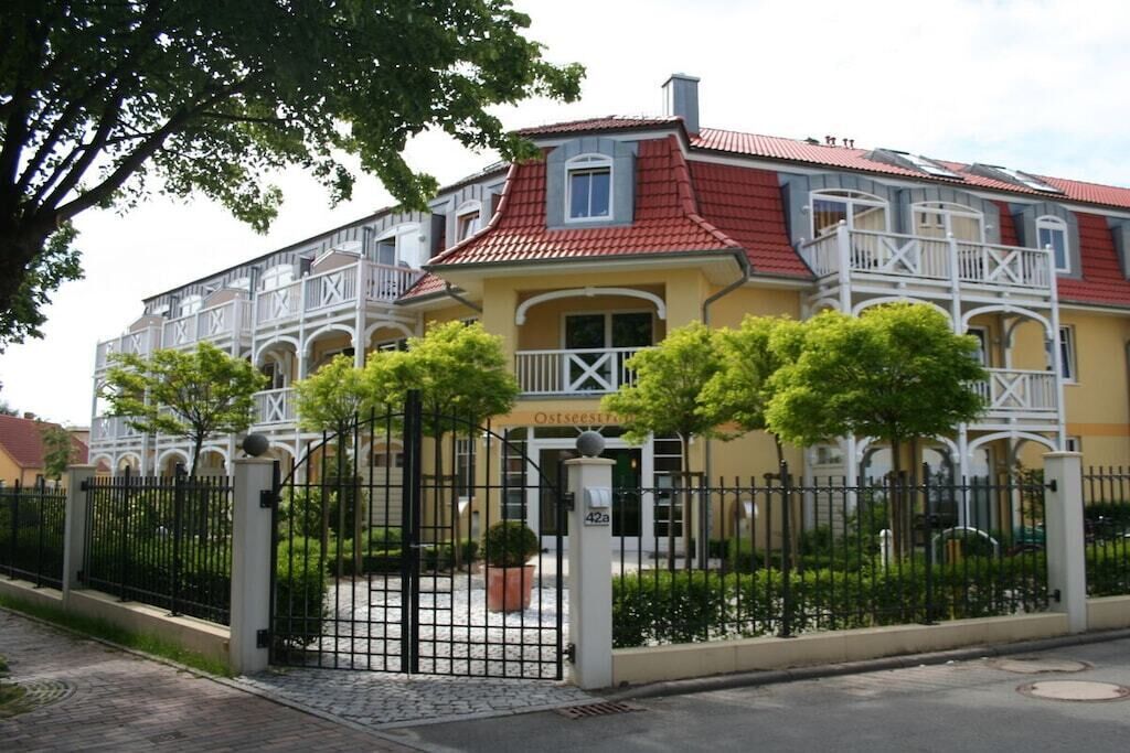 Ein zweistöckiges Gebäude mit rotem Ziegeldach, einem Balkon und einem verschlossenen Eingang.
