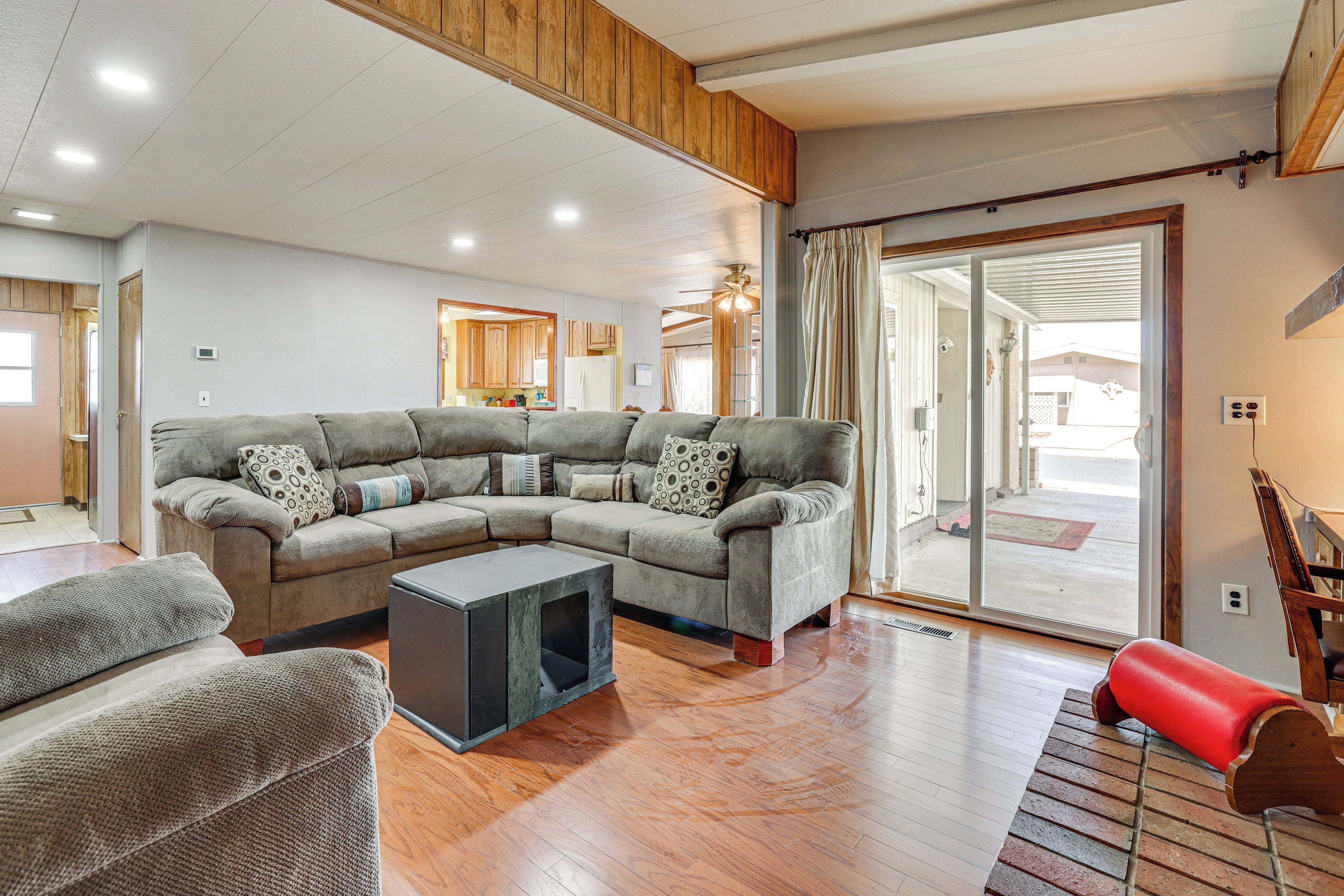 A spacious living room with a sectional sofa, a small coffee table, and a red bench.
