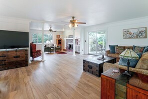A spacious living room with hardwood flooring, a fireplace, and a large window. - 1 Mi to Courthouse Plaza! Home w/ Deck + Fireplace (Prescott)