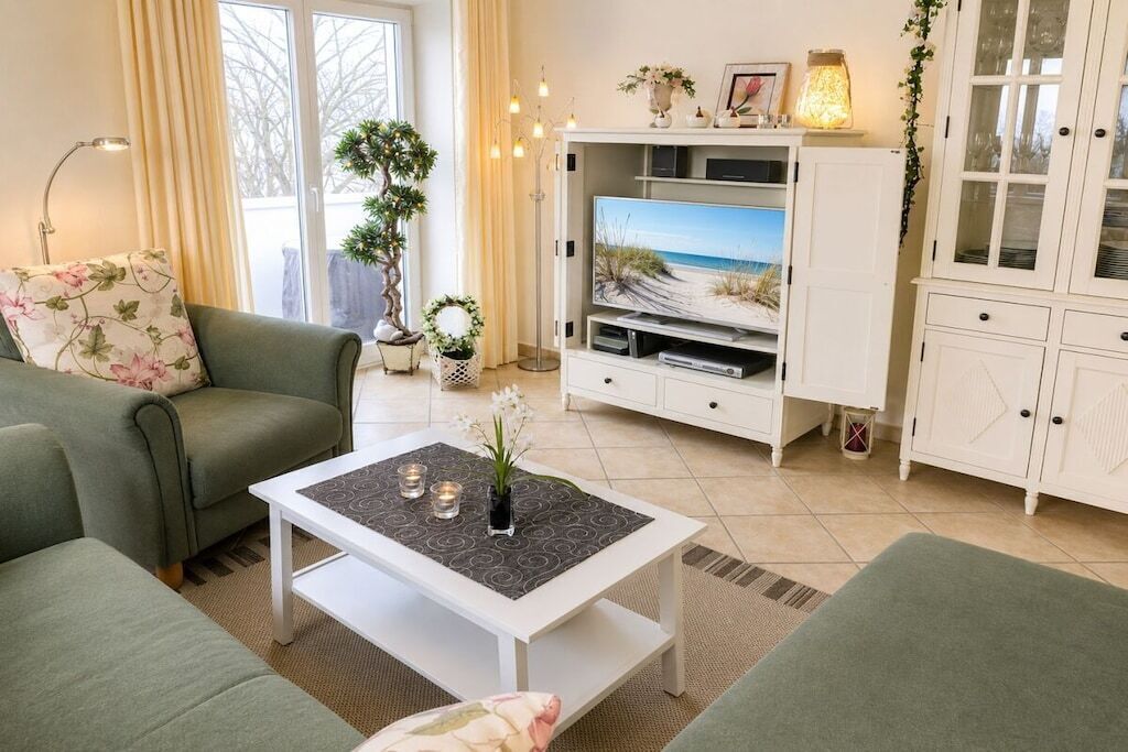 A living room with a sofa, a coffee table, a TV stand, and a cabinet.