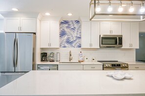 A modern kitchen with white cabinetry, stainless steel appliances, and a central island. - 3 Mins to Beach! Poolside Paradise in Siesta Key (Siesta Key)