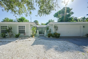 A single-story house with a garage, surrounded by gravel and small plants. - 3 Mins to Beach! Poolside Paradise in Siesta Key (Siesta Key)