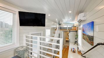Ein modernes Interieur mit Flachbildfernseher, einer Treppe und einer Küchenzeile.