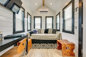 A compact room with a bed, a desk, and a chair. - Gateway to Red Rock Adventures! Resort Tiny Home (Hurricane)