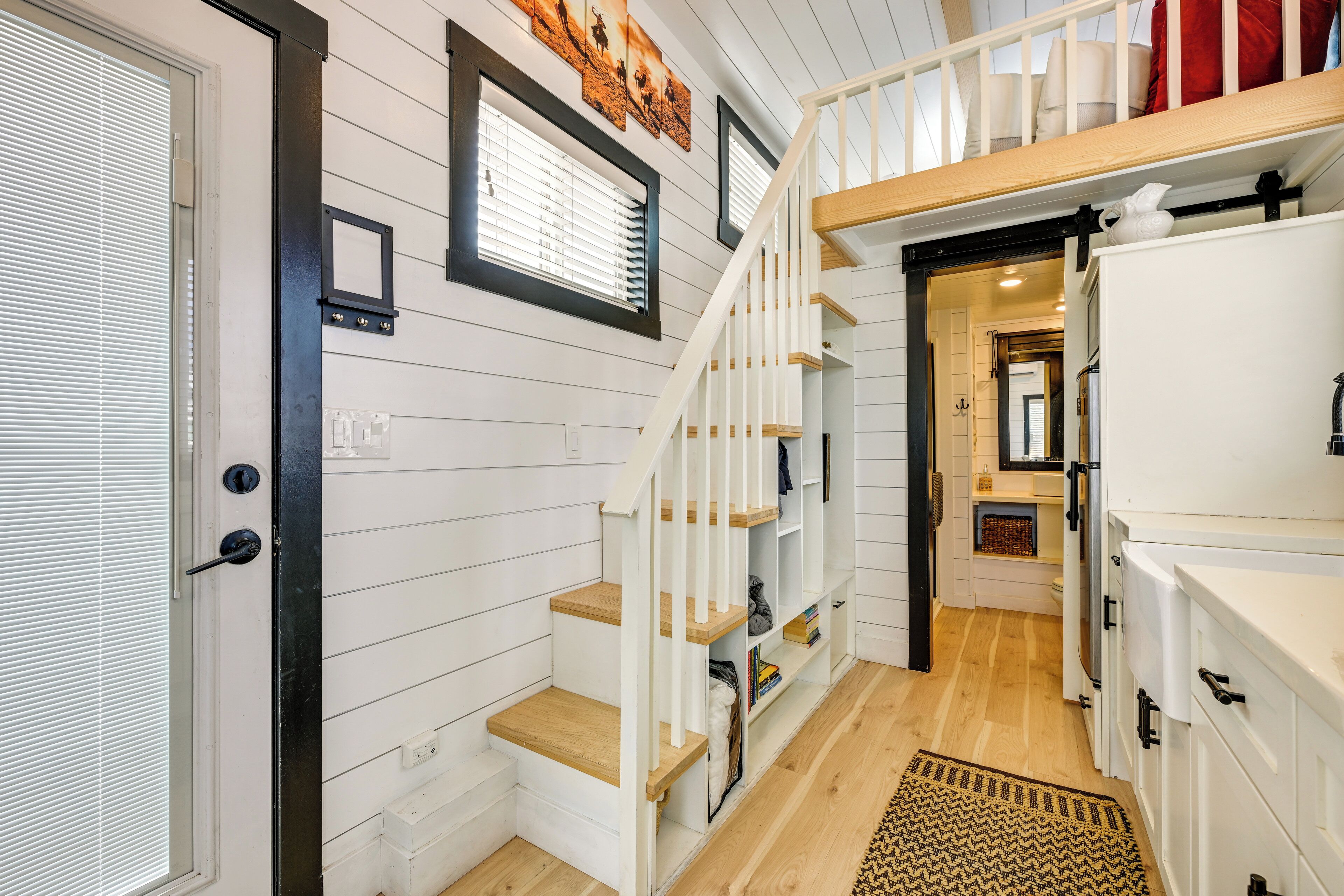 A staircase with white railings and wooden steps leading to a second floor.