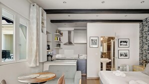 A modern hotel room with a kitchenette, a dining area, and a bathroom. - Charmante maison au cœur de Paris – Face au Louvre • 2 personnes (Paris)