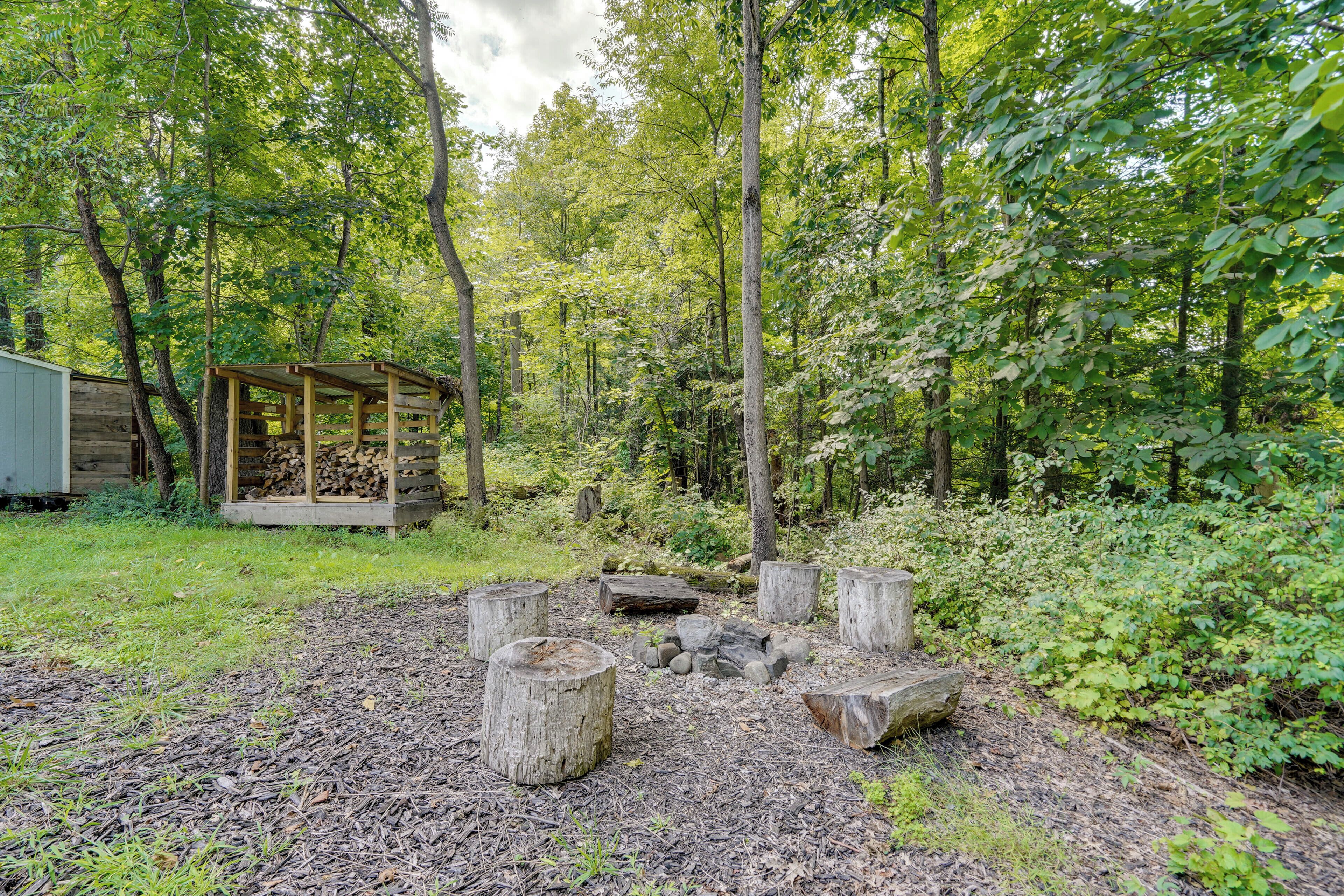 A rustic wooden cabin with a covered porch in a forested area.