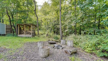 A rustic wooden cabin with a covered porch in a forested area.