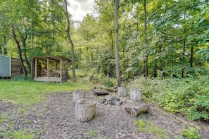 A rustic wooden cabin with a covered porch in a forested area.