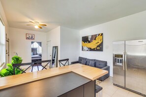 A modern kitchen with a stainless steel refrigerator, a dining area with a wooden table and chairs, a gray sofa, and a ceiling fan. - Easy Airport Access, Near Parks! Elizabeth Retreat (Elizabeth)