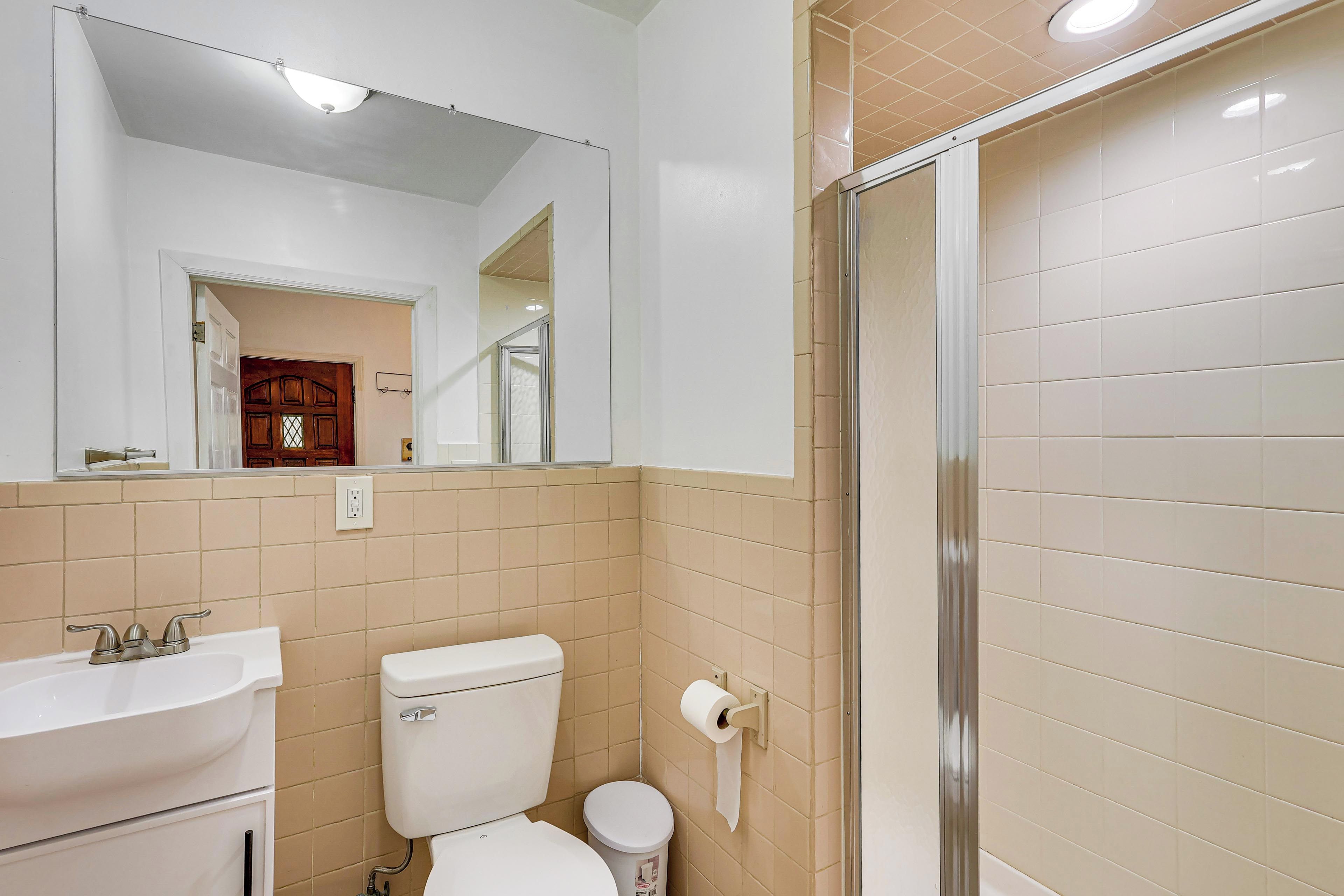 A bathroom with a toilet, sink, and a shower area.