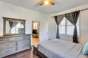 Un dormitorio con cama, cómoda y ventilador de techo.