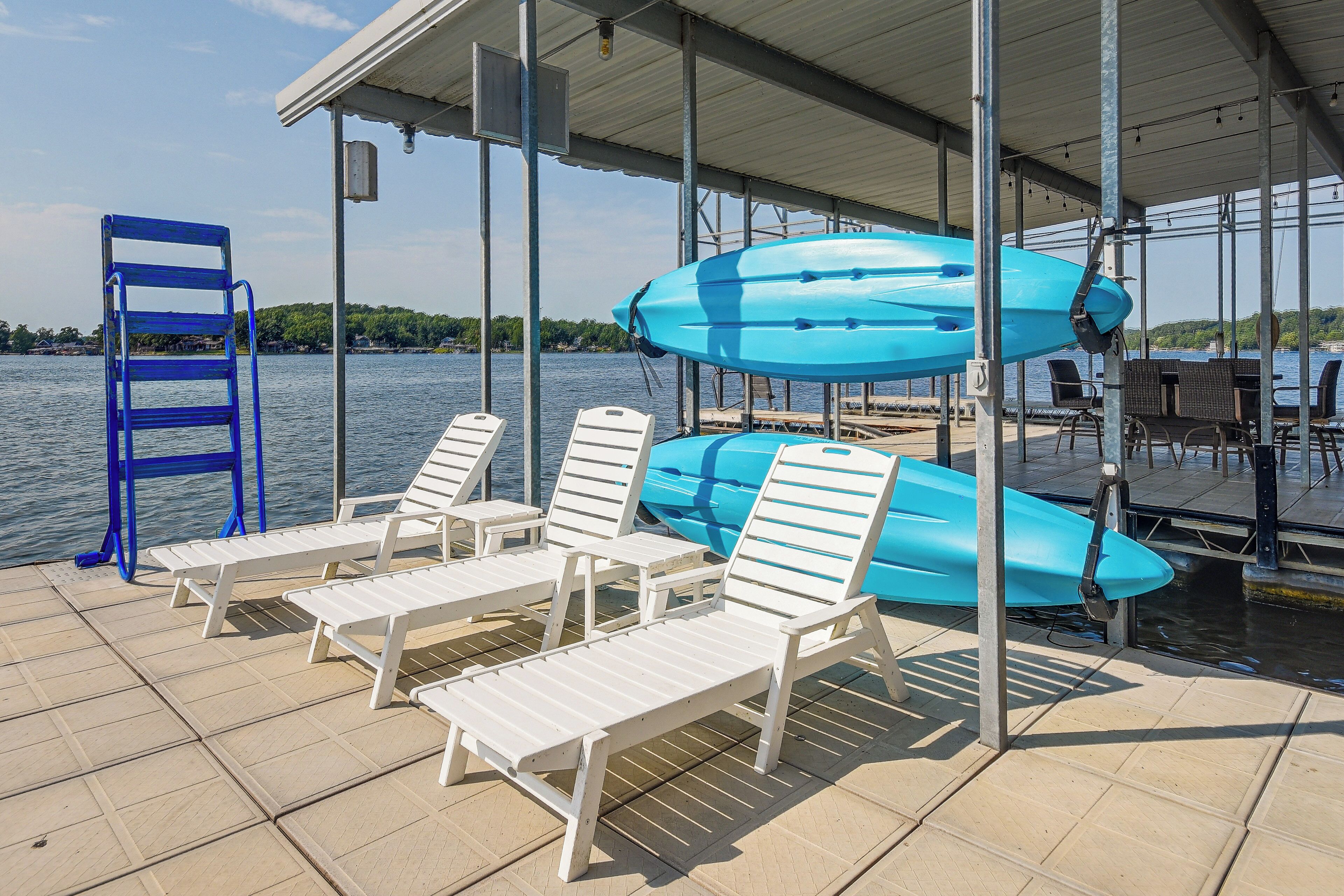 Eine überdachte Terrasse mit weißen Liegestühlen und einem blauen Kajak.