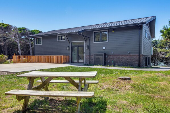A modern two-story building with a flat roof, a front door, and a small porch area.