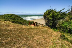 A wooden staircase leading down to a beach with ocean views.