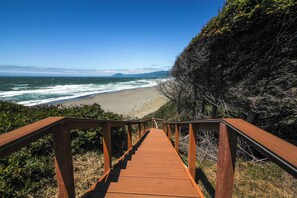 A wooden staircase leading to a beach with ocean views. - Beachfront, Pool, and Views on Oregon Coast: 5BR (Gold Beach)