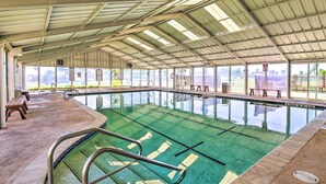An indoor swimming pool with clear lanes, benches, and a covered roof. - Private Dock, Pool Access: Oceanfront Cottage (Port Isabel)