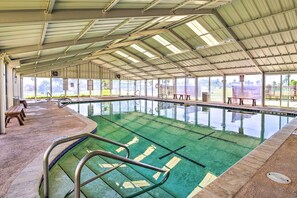 An indoor swimming pool with clear lanes, benches, and a covered roof. - Private Dock, Pool Access: Oceanfront Cottage (Port Isabel)