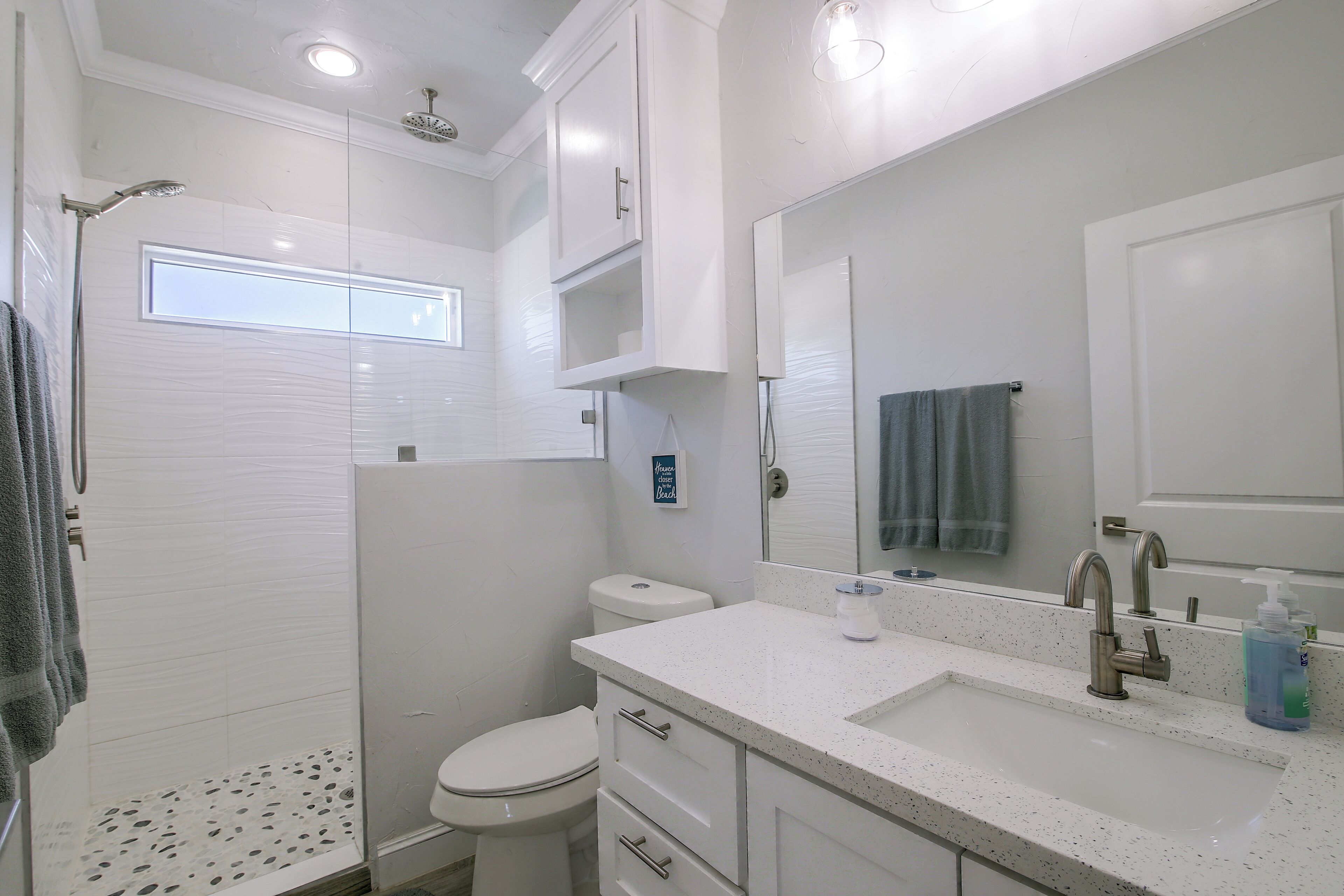 Une salle de bain moderne équipée d’une douche, de toilettes et d’un lavabo.