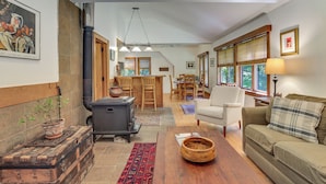 A cozy living room with a fireplace, wooden furniture, and a dining area with a view. - Deck & Wooded Views! 2 Mi to Frederick Gunn School (Washington)