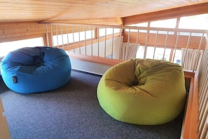 Two bean bags in a room with a wooden ceiling and a view through a window. - Holiday apartment House Mecklenburg 322202 (Kühlungsborn)