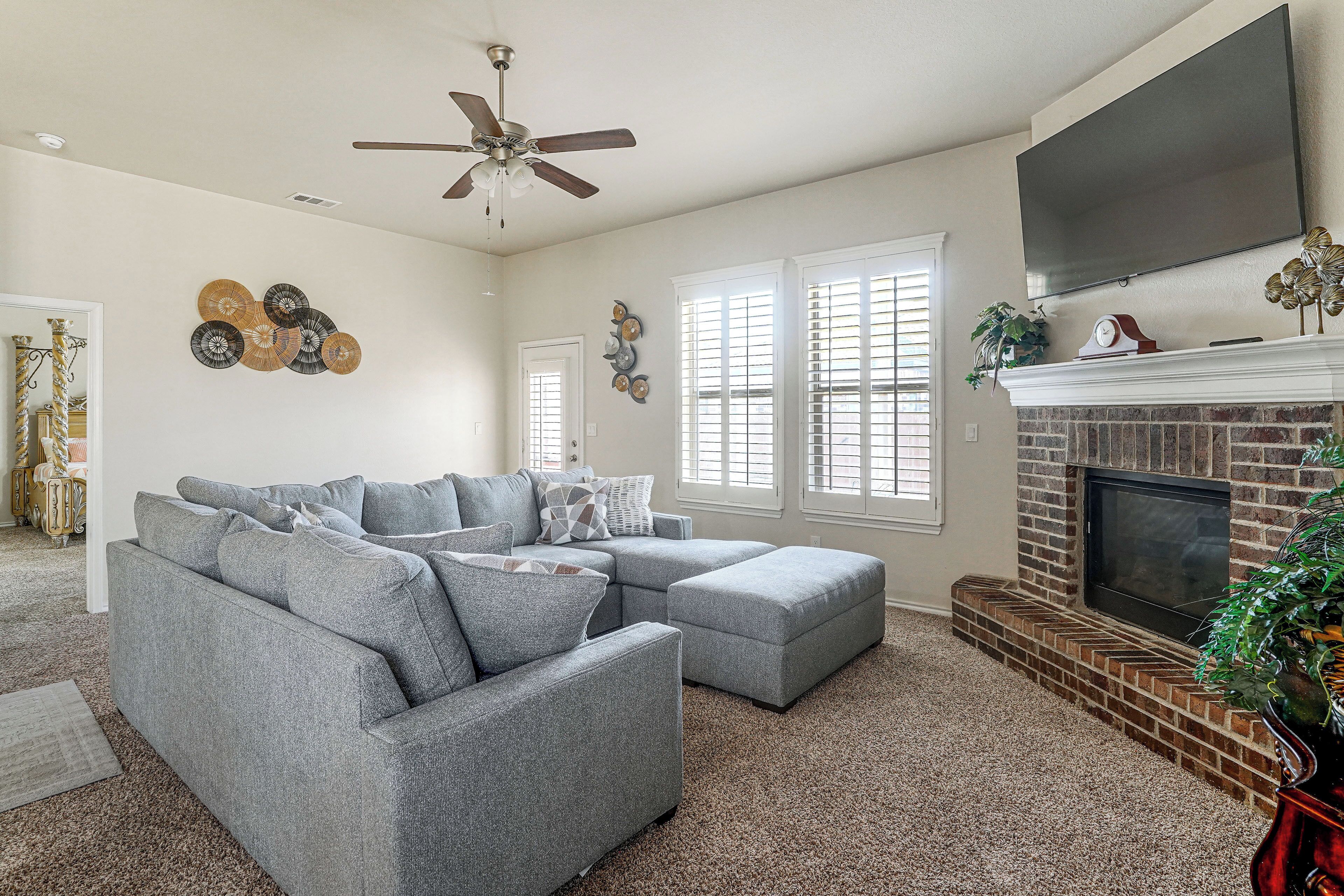 A living room with a sectional sofa, a fireplace, and decorative wall art.